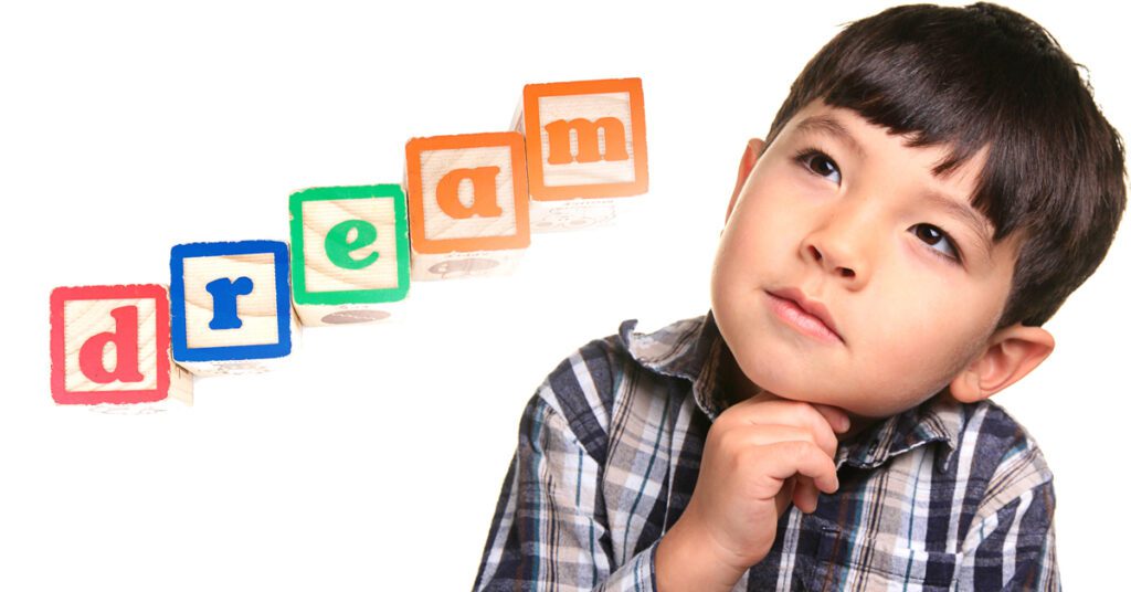 A young boy with blocks that spell out "dream"