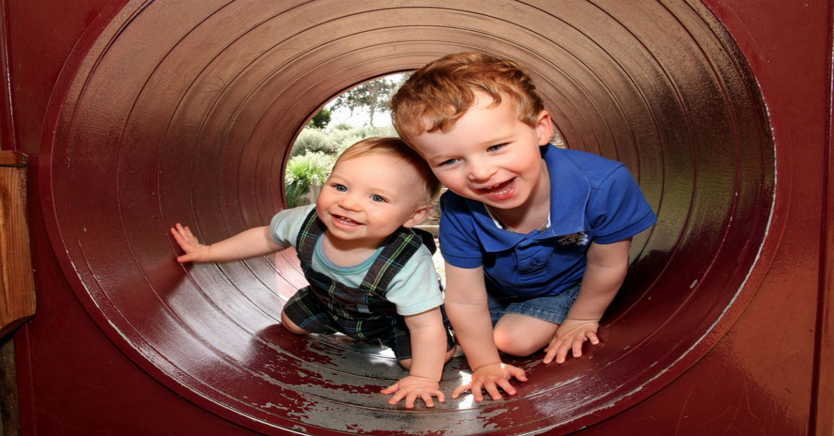 Two children playing in a play tunnel
