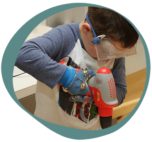 a student using a toy drill at one of our educational centers