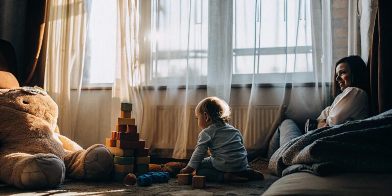 A child and parent exploring the learning through play curriculum with building blocks.