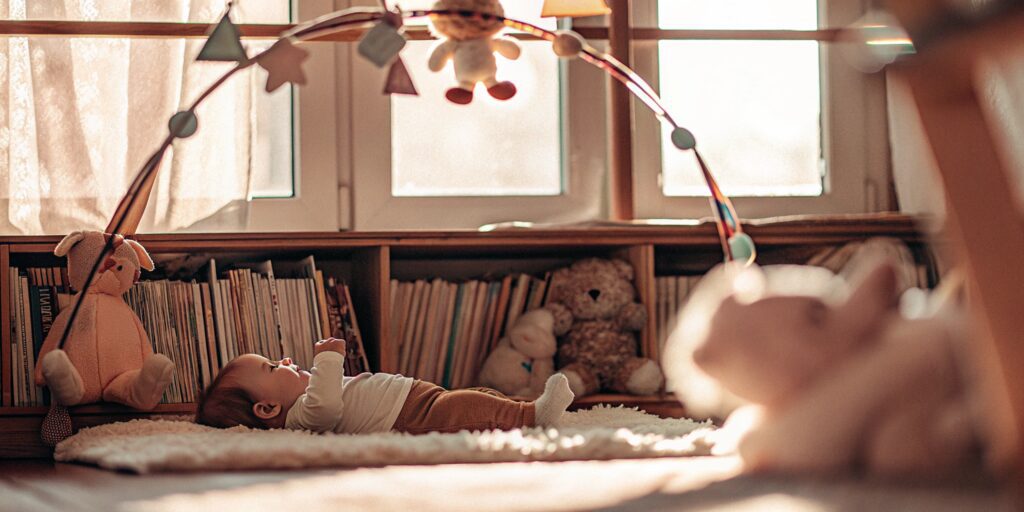 Infant on a play mat enjoying early learning with colorful toys and books.