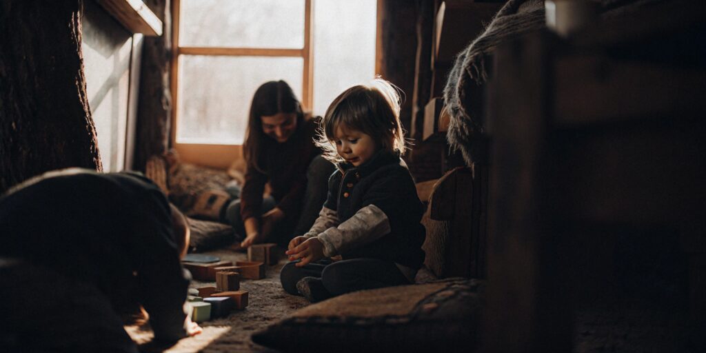 A sunlit Reggio Emilia classroom where children learn by playing with wooden blocks.
