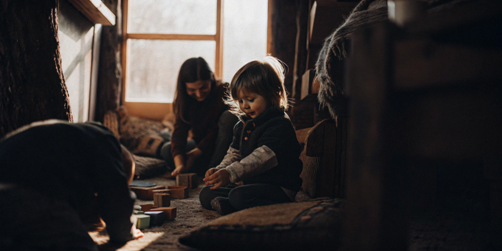 A sunlit Reggio Emilia classroom where children learn by playing with wooden blocks.