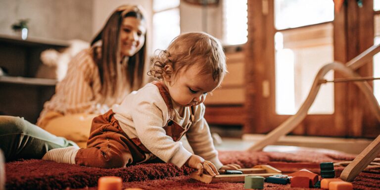 A child explores educational toys in a learning daycare while a teacher observes.