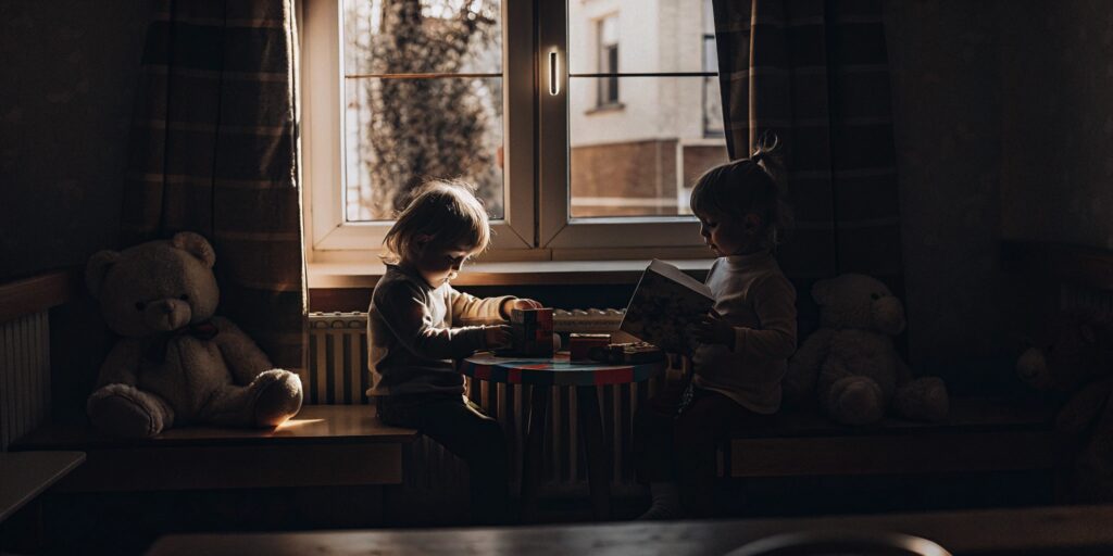 Two children in a preschool program build reading and social skills for kindergarten readiness.