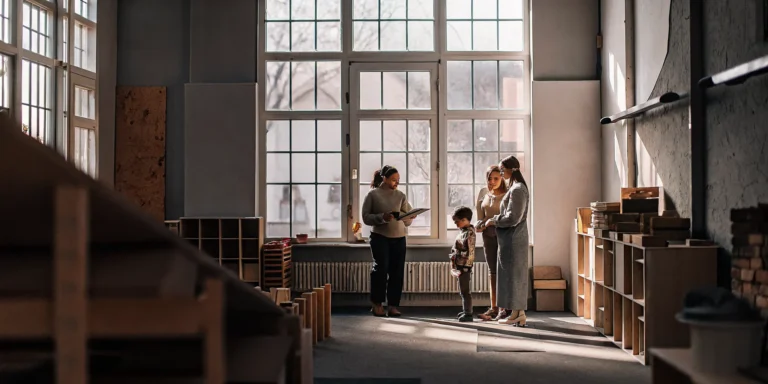 Parents on a tour of a quality educational daycare meeting a teacher in Bridgeport, CT.