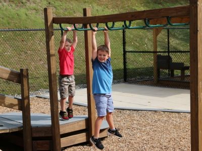 children playing on the monkey bars at one of our playgrounds