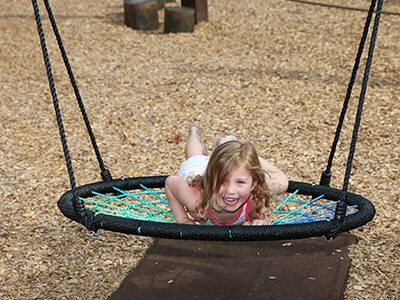 a child on a swing on one of our playgrounds