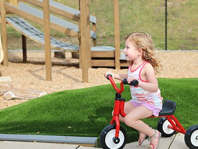 a young girl on a tricycle